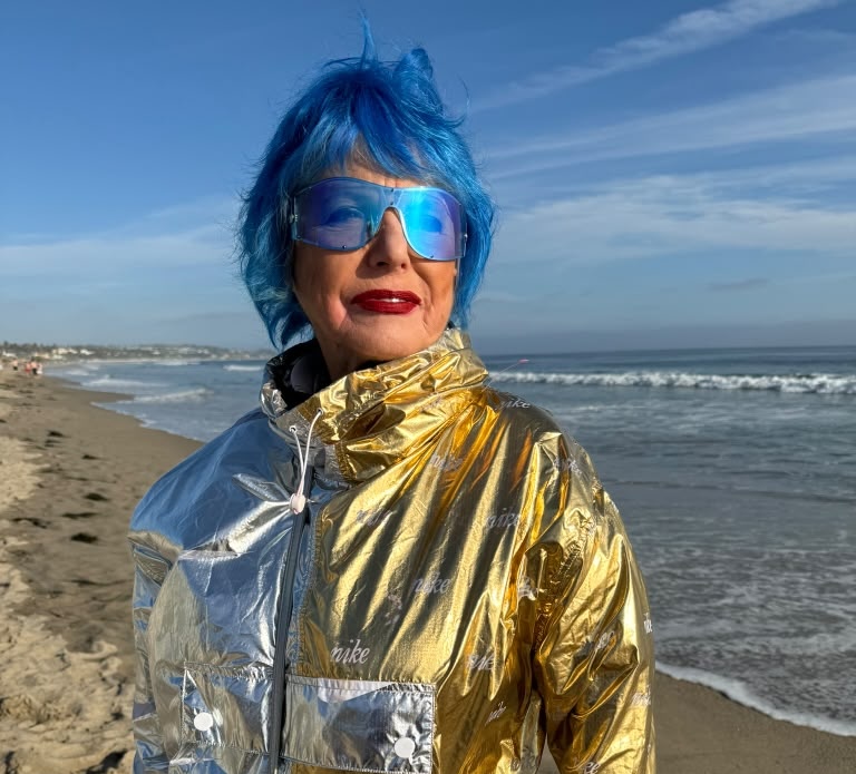 Eva Blaisdell in a metallic gold and silver jacket on the California shoreline