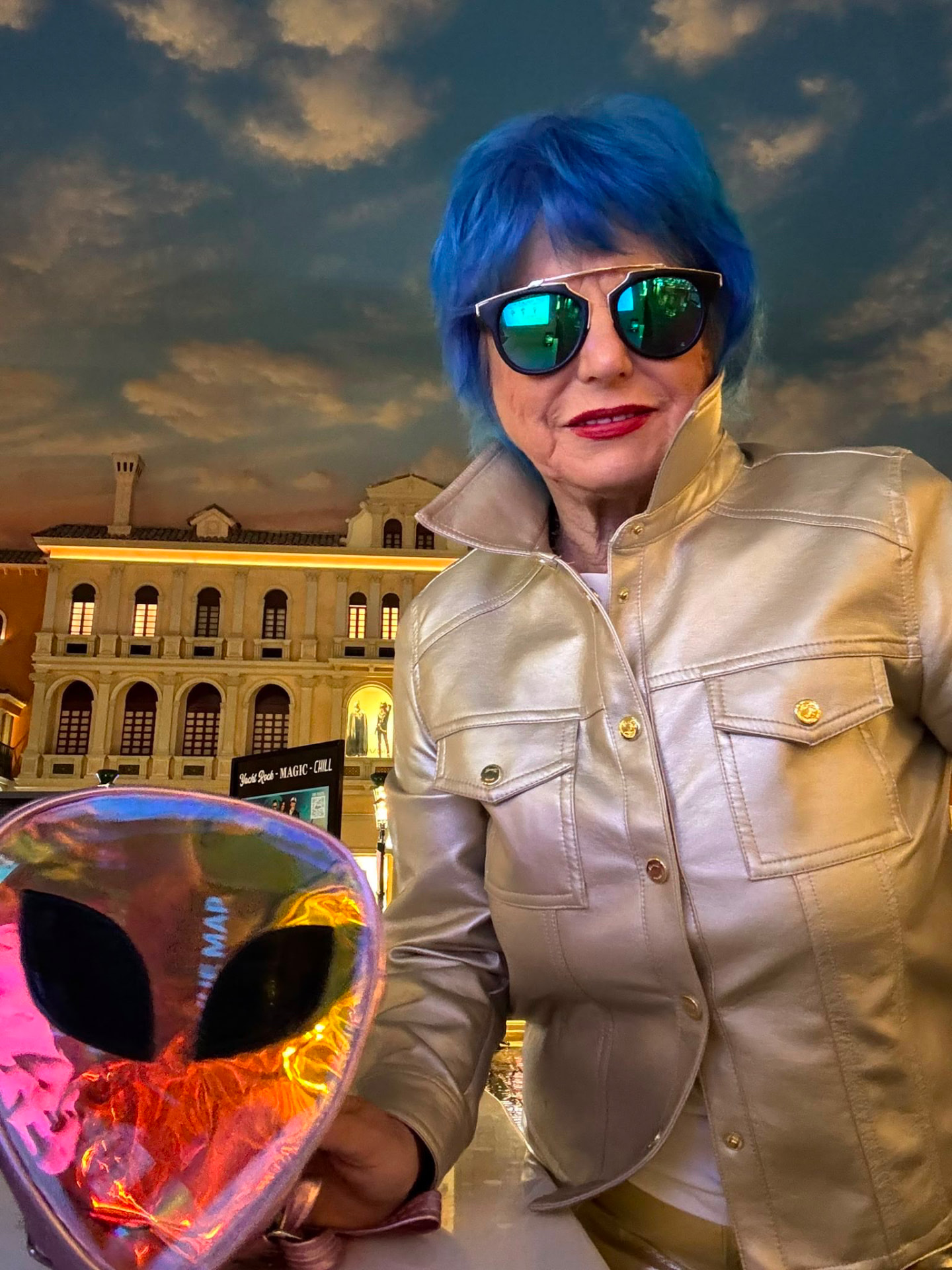 Eva Blaisdell in a gold jacket inside a luxury interior, holding a sculptural holographic piece